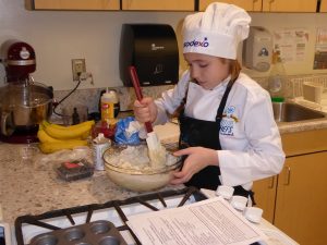 Child mixing dough in a bowl