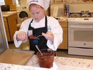 Child whipping chocolate substance